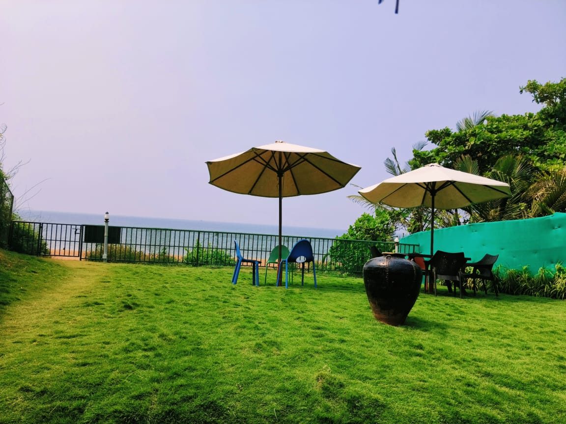 The garden deck above Candolim beach — umbrellas, Raht Aashyana Lakhanpal, Candolim, Goa
